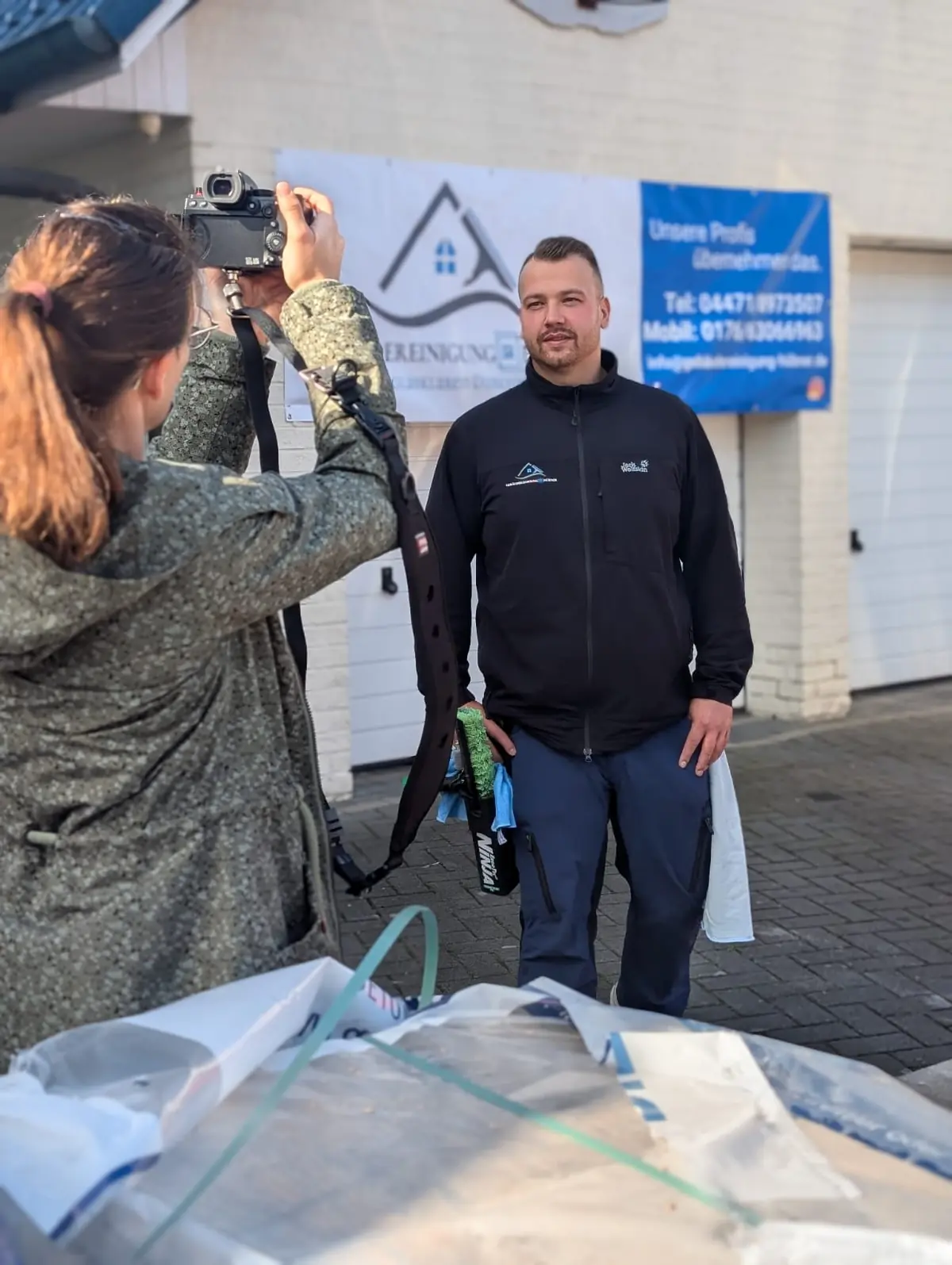Noell Hübner, Inhaber der Gebäudereinigung Hübner, beim Fototermin vor dem Firmenbanner